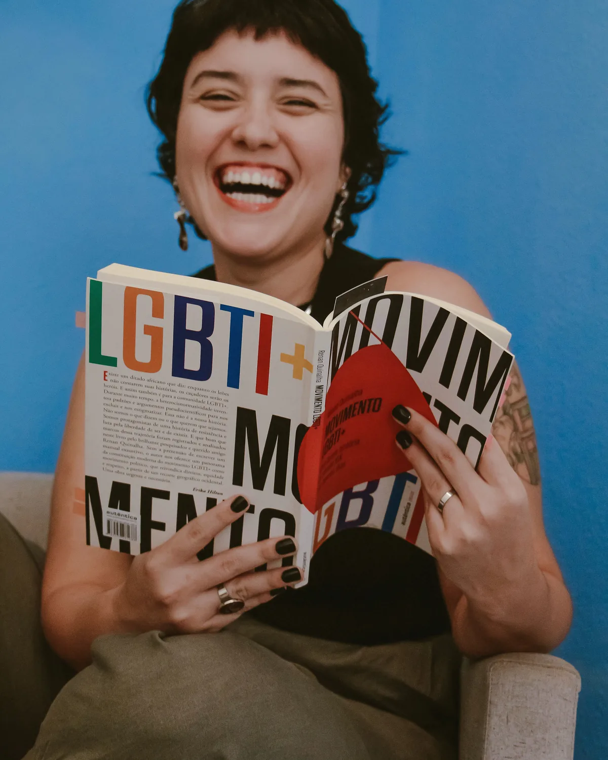 Veri rindo com o livro Movimento LGBTI+ aberto